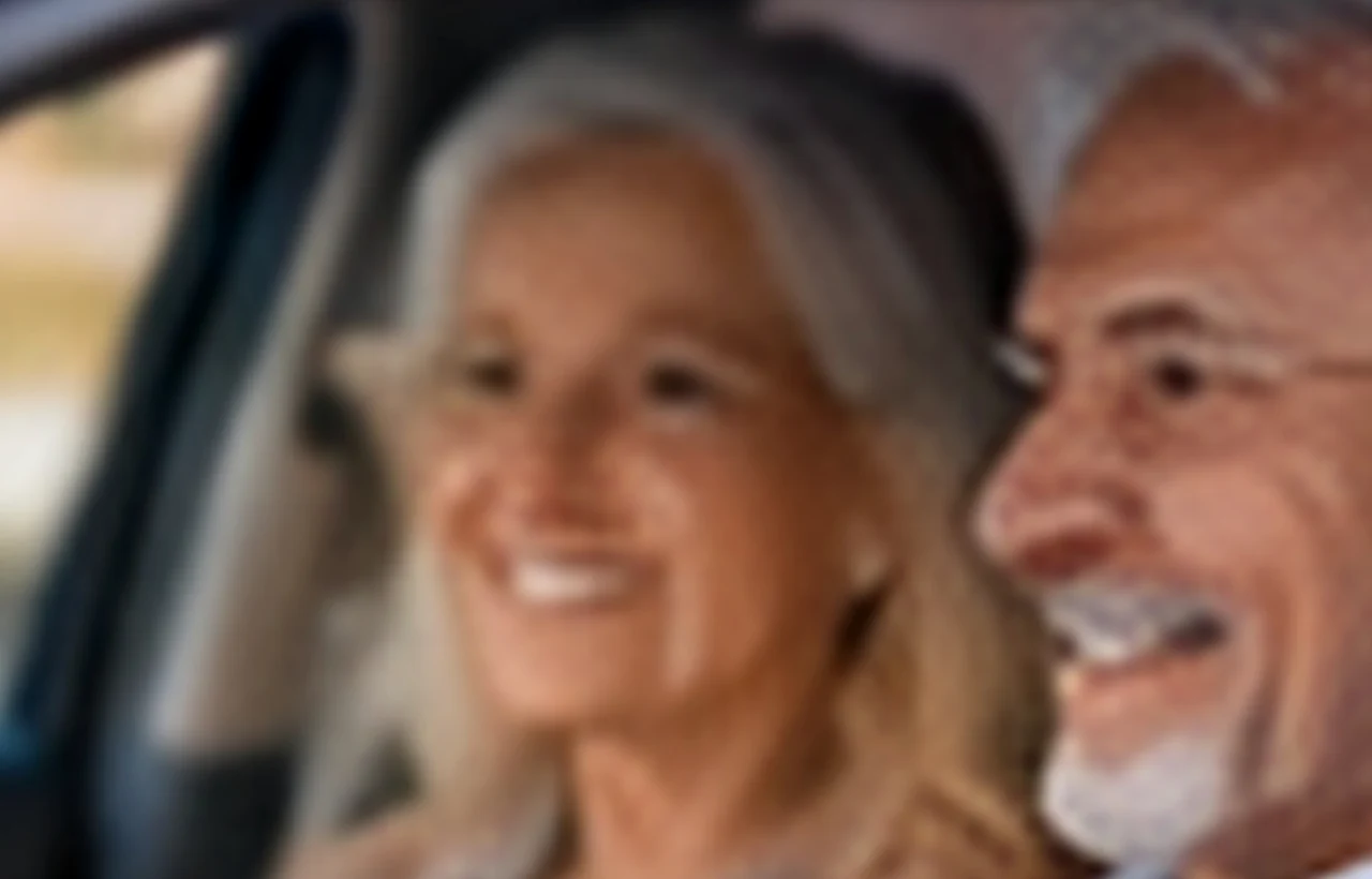 Woman in her late fifties signing a car order form at a dealership